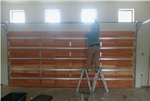Technician installing a timber-look sectional garage door