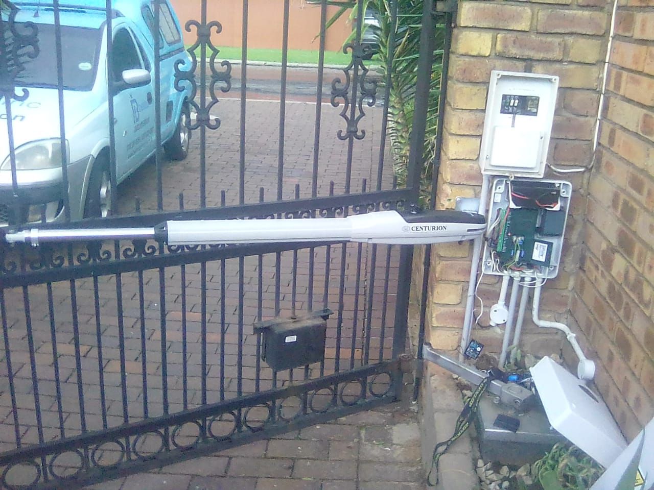 Swing gate motor arm and control box mounted on a gatepost
